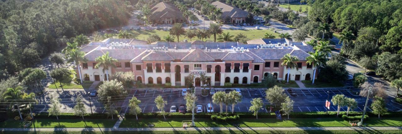 Bird eye view of Hodges University building, blue skies and trees around the facility