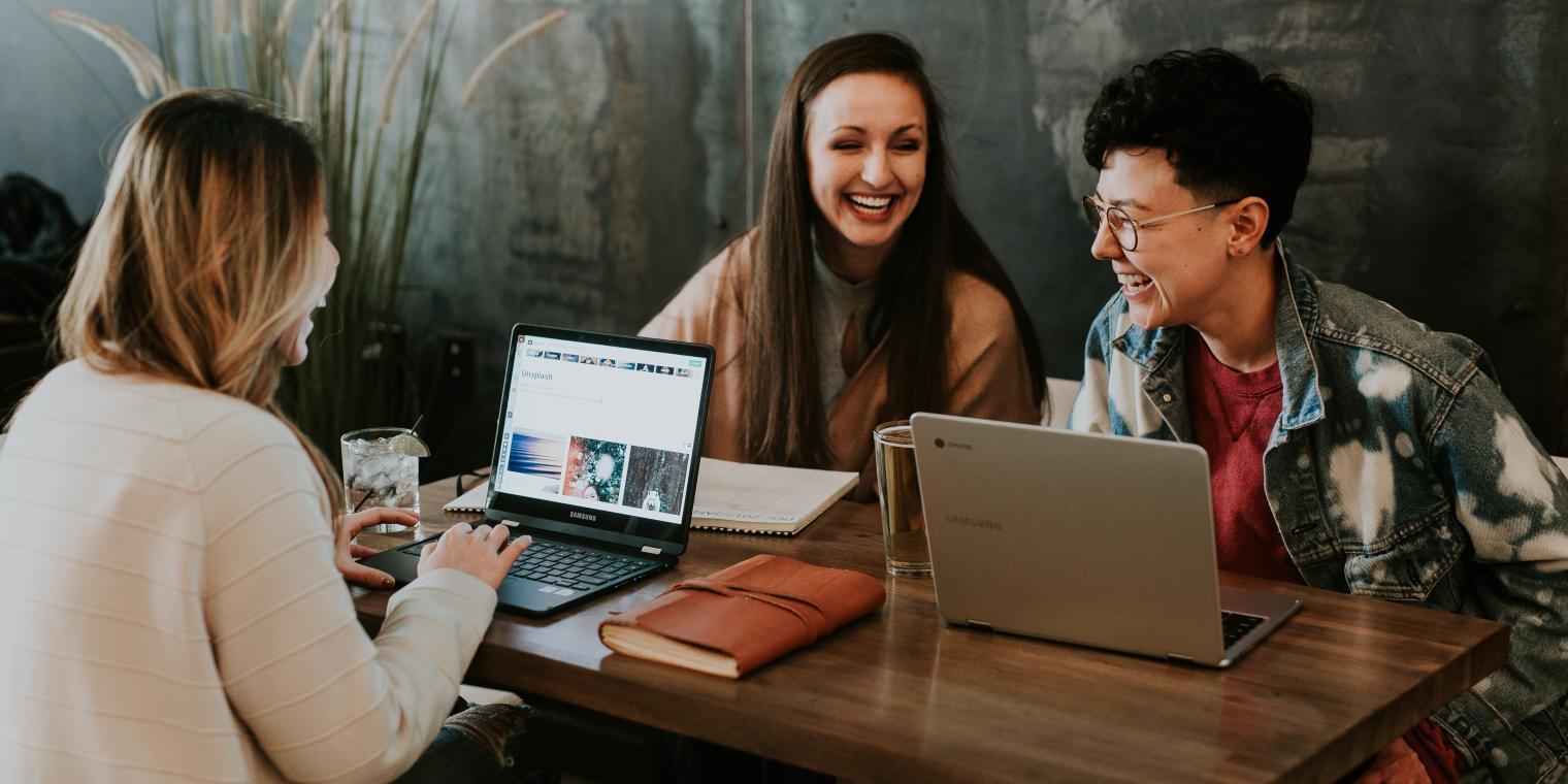 group of students laughing on their laptops