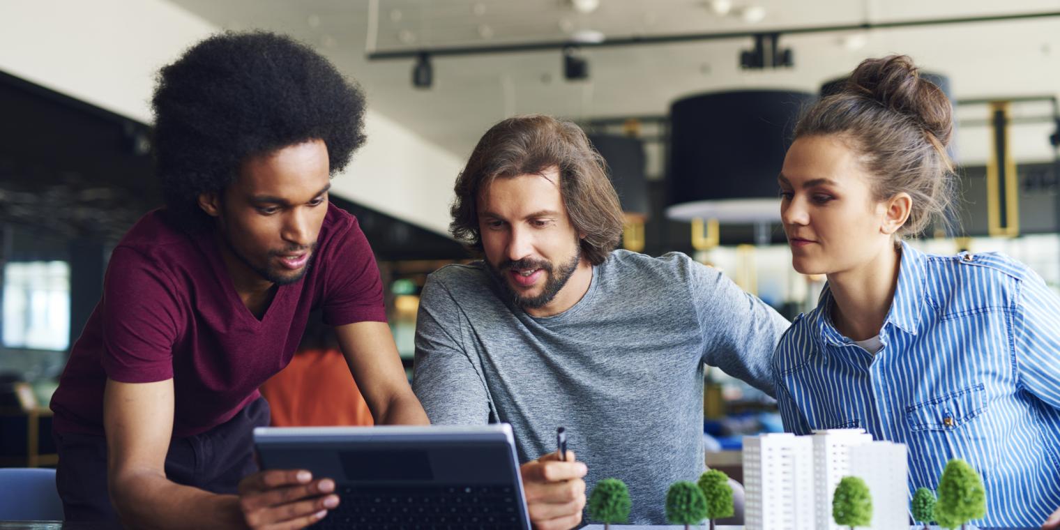 3 people meeting and pointing at a tablet